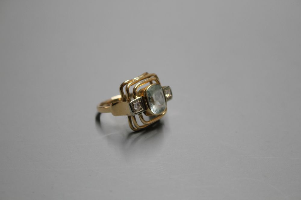 A 585 yellow metal, aquamarine and diamond set three stone dress ring, with pierced stepped setting,